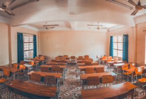 empty classroom with rows of wooden desks and chairs