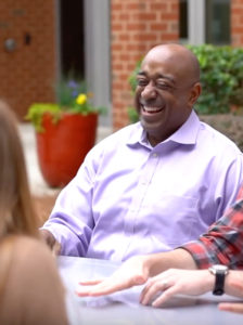 Donald Thompson outside at a table laughing