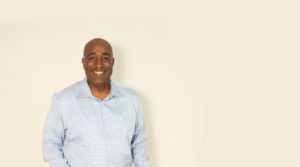 Donald Thompson smiling with plain wall background